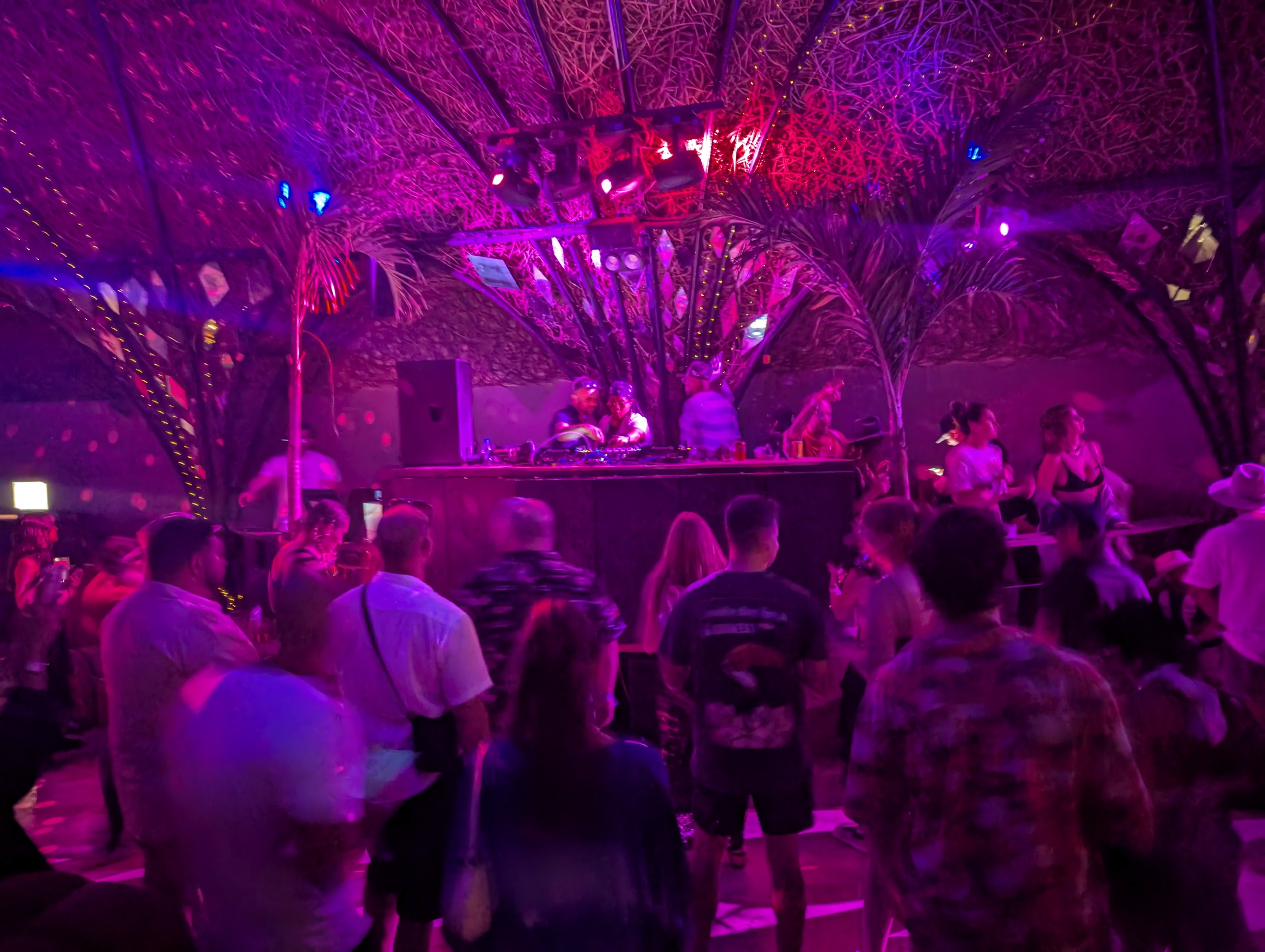 Indoor venue with pink and magenta lighting at Destination Unknown