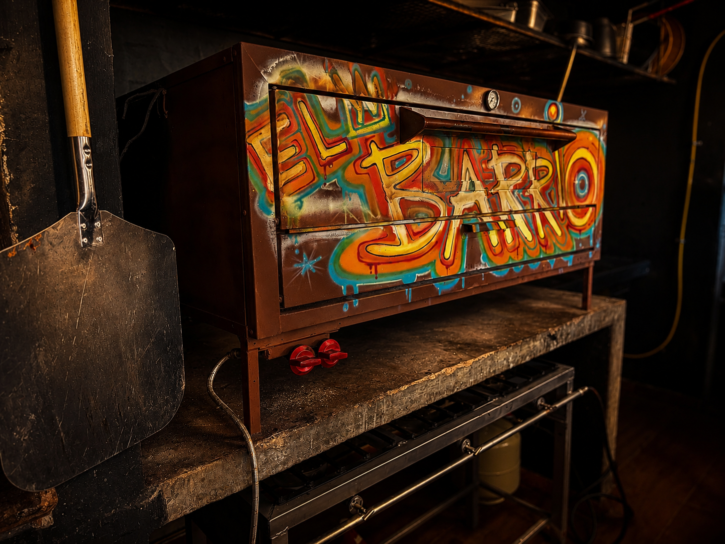 El Barrio branded pizza oven with graffiti lettering