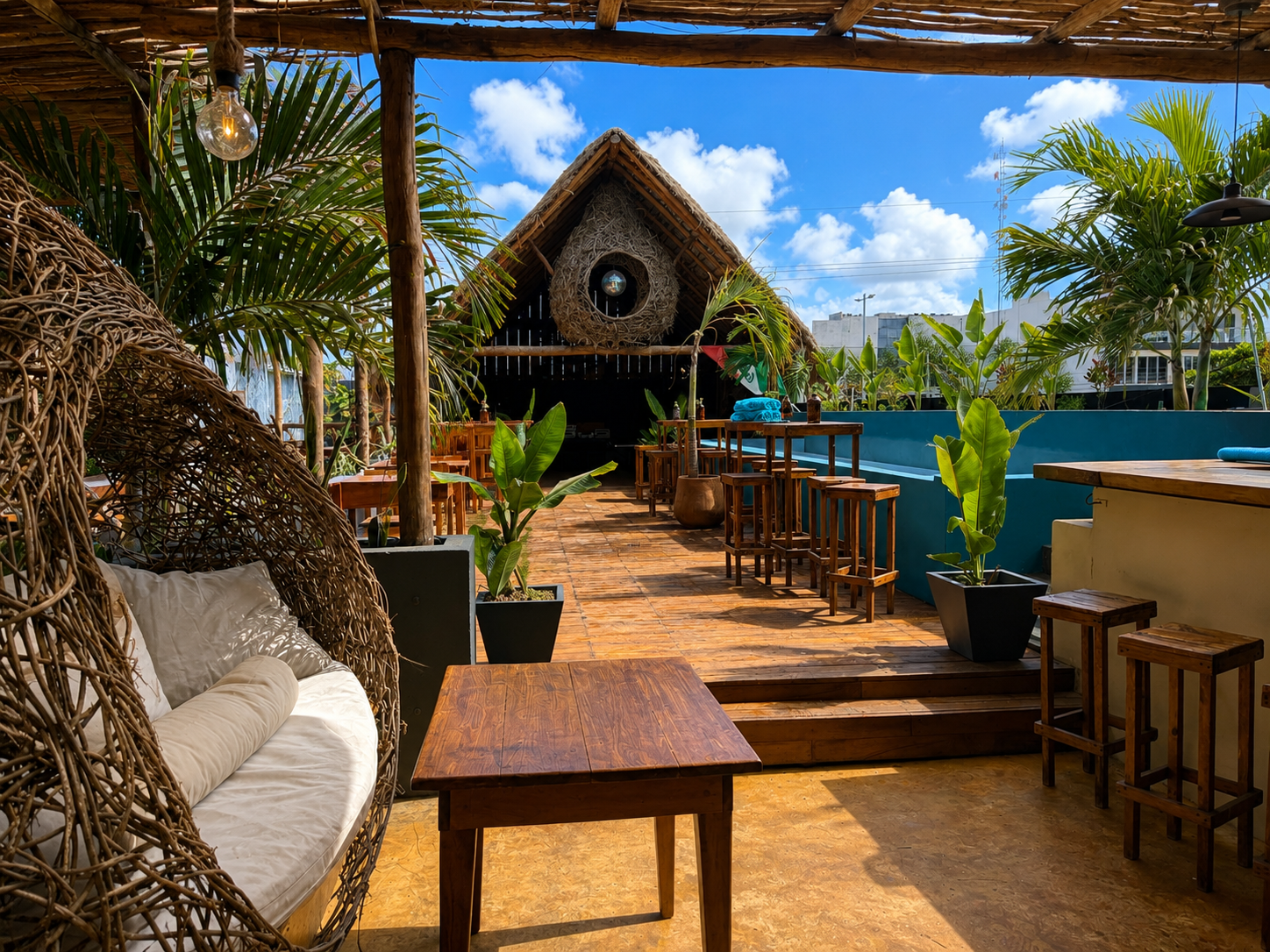 El Barrio outdoor venue with woven seating, pool, and thatched stage